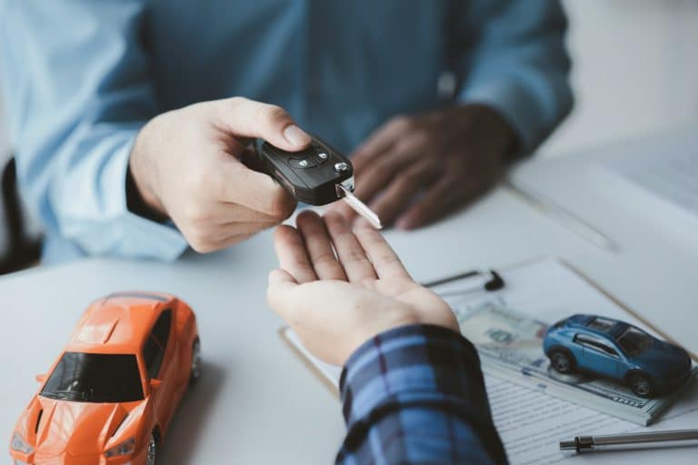 A car rental company employee pointed out the renter to sign the rental agreement after discussing t