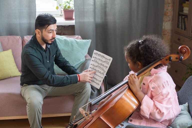 Confident music teacher pointing at paper with notes during home lesson