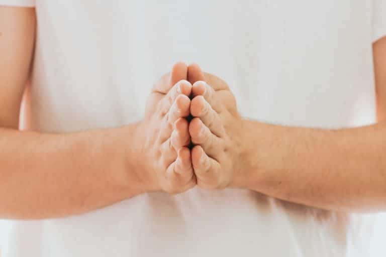 Praying hands with faith in religion and belief in God on dark background
