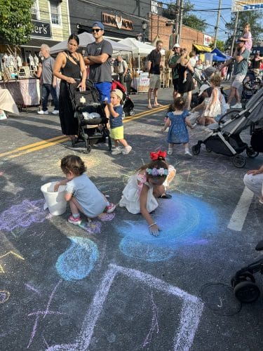 Summer in the Streets July 24 children drawing with chalk on the street