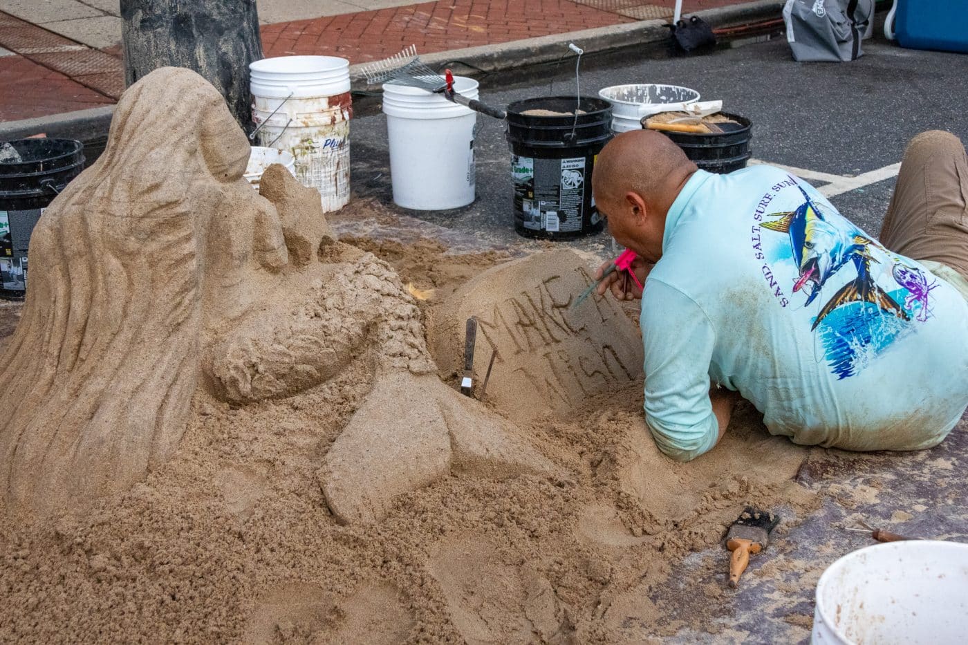 Man making a mermaid sand sculpture