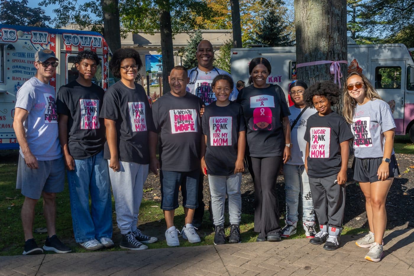 3 year Breast Cancer Survivor surrounded by her family and friends wearing matching t-shirts "I wear Pink for My Mom, Wife, Friend". Pink in the Park 2025.