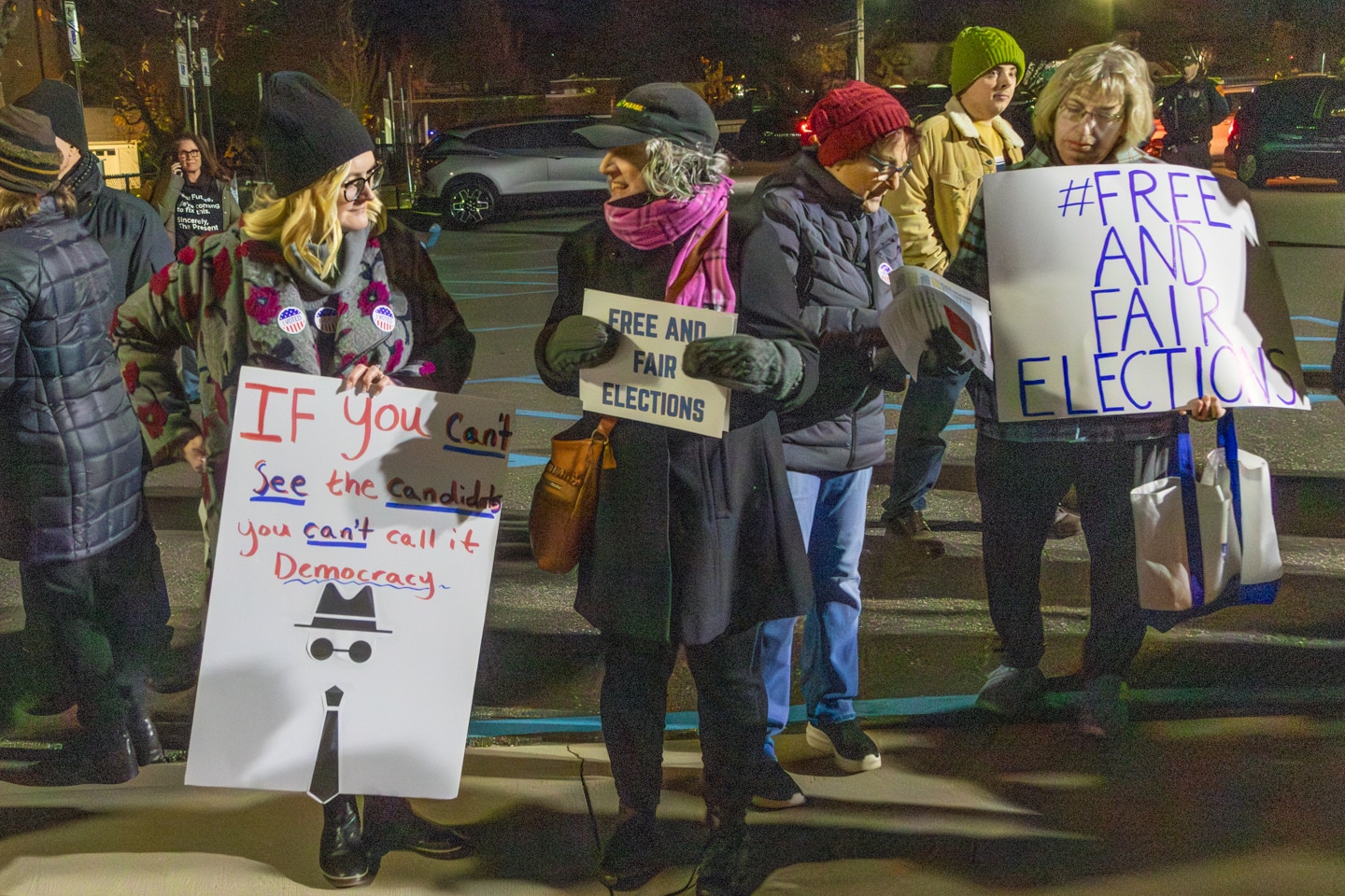 Protest Organizer Quinn Dell speaks with fellow attendees holding signs "Free and Fair Elections". Huntington Election Protest