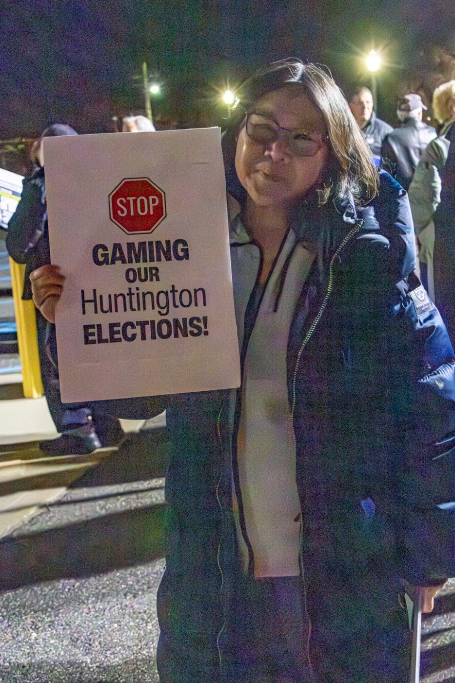 Protestor holding sign "Stop Gaming Our Huntington Elections!" Huntington Election Protest