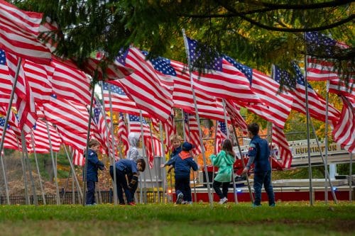 Child scouts playing among the American Flags. Huntington Veterans Wreath Laying Ceremony