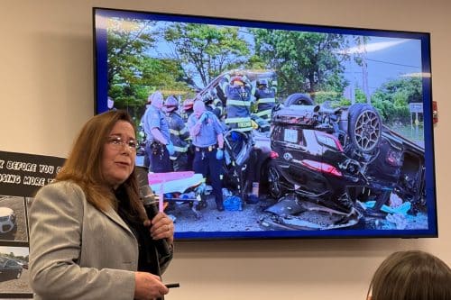 Maureen McCormick - Special Assistant District Attorney for Legislative Initiatives shows a photograph of first responders opening a car to extract victims of a drugged driving accident. Drugged driver accident. Law Enforcement Community Advisory Board Meeting