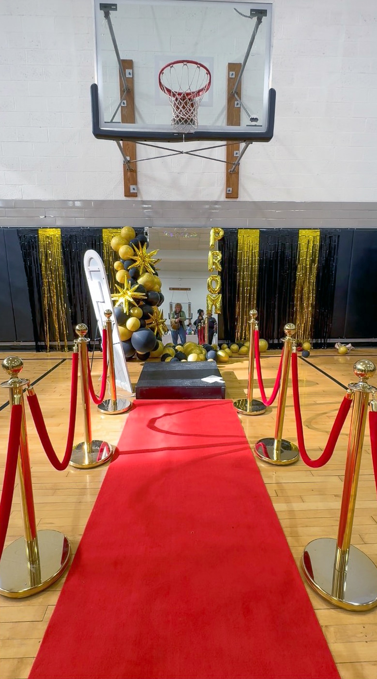Project Prom's red carpet with mirrored pedestal for selecting the perfect outfit. Project Prom Transforms Huntington Senior Center into a Prom Boutique