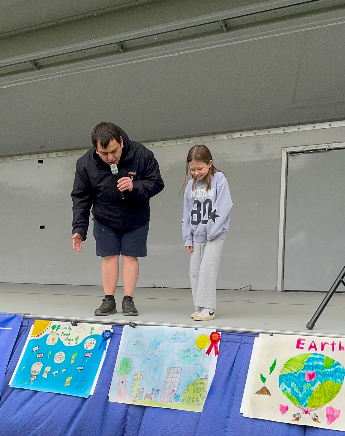 EmCee Anthony speaks to the child winner of the poster design contest, highlighting her design. Huntington Family Earth Day Highlights Environmental Programs and Wildlife Education
