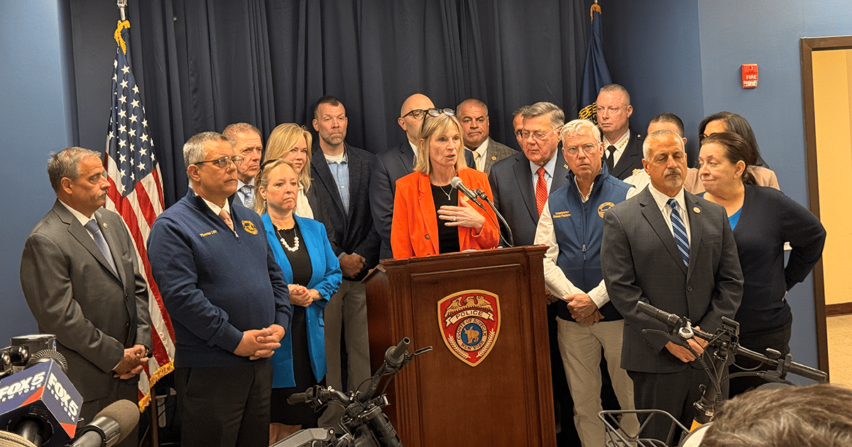 Town of Huntington Suffolk County Legislators Stephanie Bontempi (orange) and Rebecca Sanin (bright blue) with County Executive Ed Romaine (red tie) and officials. Suffolk County Enforces New E-Bike and E-Scooter Laws Focused on Safety