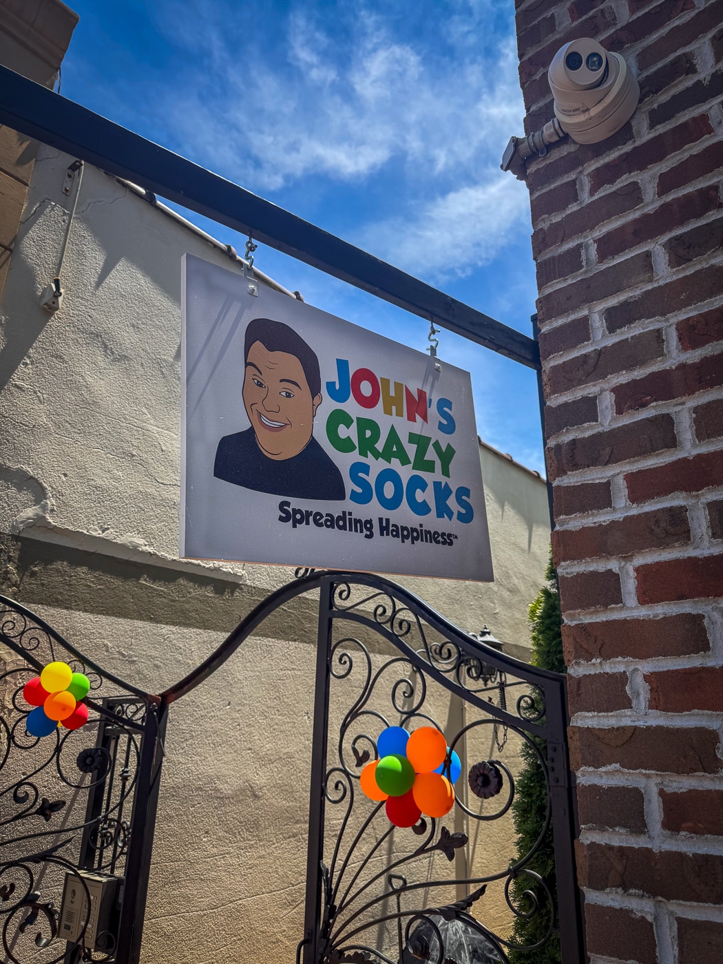 The John's Crazy Socks Retail Store sign hangs above the ornate gates leading to their new retail store at 328A Main St, Huntington, NY. John's Crazy Socks Opens First Retail Store in Huntington Village