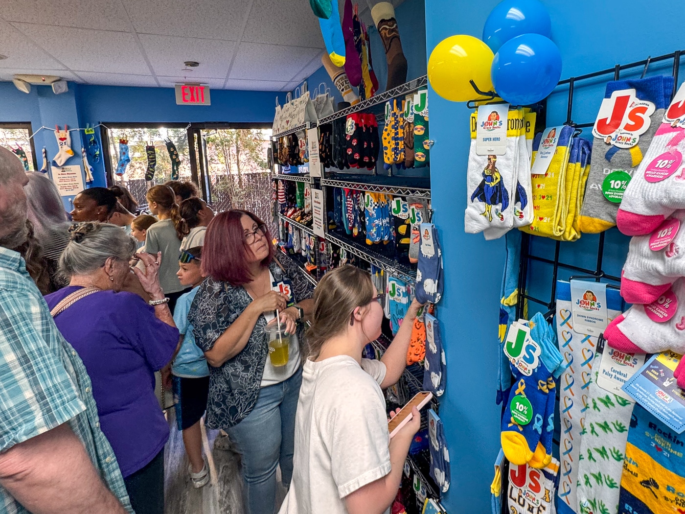 Crowds of people fill the new retail store to shop for socks. John's Crazy Socks Opens First Retail Store in Huntington Village