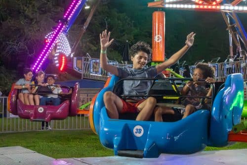 Children enjoying a carnival ride at night. Summer Carnival Brings Families Together at Breezy Park