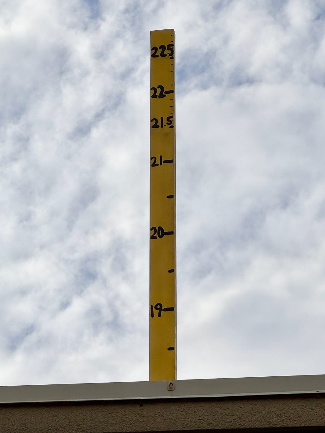 A ruler mounted to the roof of Jonny D’s Pizza marks the challenge ahead. A dough toss over 21.5 feet will beat the current world record.Huntington’s Jonny Dawson Is Tossing for a World Record - and a Good Cause