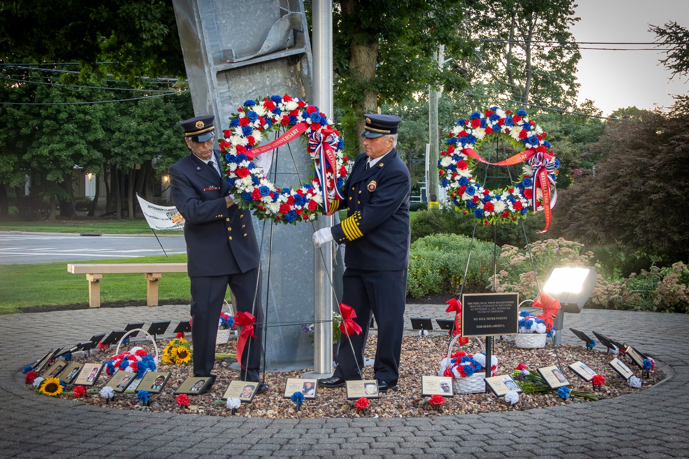Melville Fire Department member place ceremonial wreaths on their September 11 Memorial surrounded by photographs of neighbors lost. Photo Stories: Melville Remembers