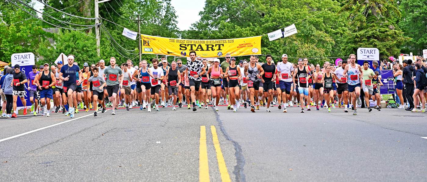 8:32AM 3rd wave of 2000s runners leave the Starting Line on Laurel Avenue in Northport, 2026 Great Cow Harbor 10K Run